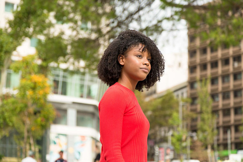 Confident young woman walking outside in the city